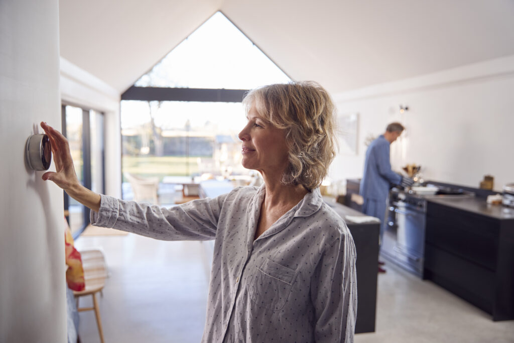 Woman adjusting her home thermostat